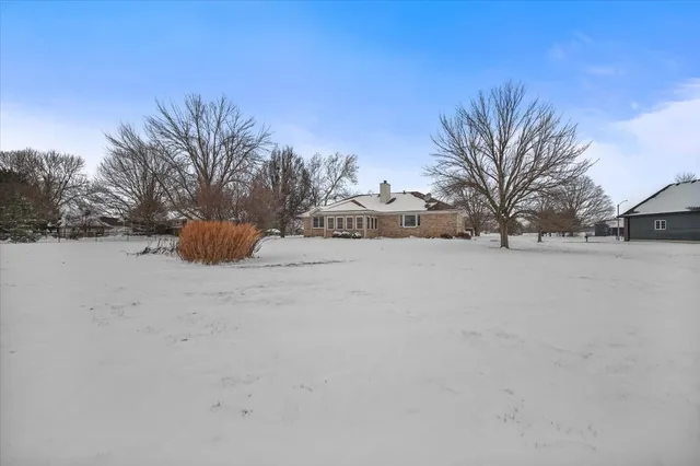 a view of road covered with snow in middle of house