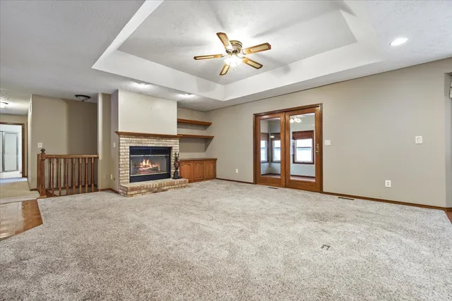 an empty room with windows and fireplace