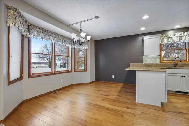 a view of kitchen with granite countertop cabinets and window