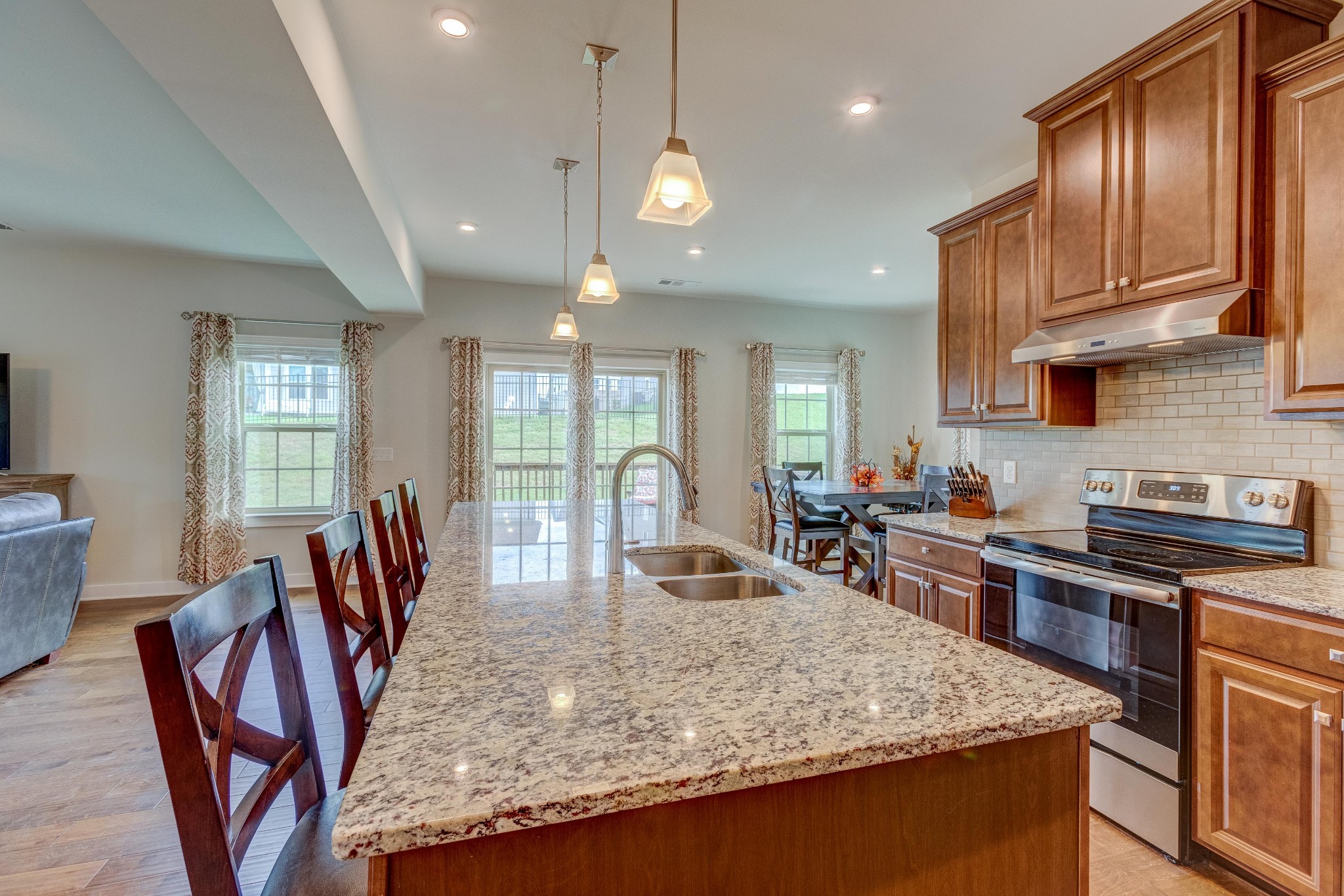 315 Collier Road Mount Juliet, TN 37122 - Photo 4 of 34 a kitchen with stainless steel appliances granite countertop a stove top oven a sink a dining table and chairs with wooden floor