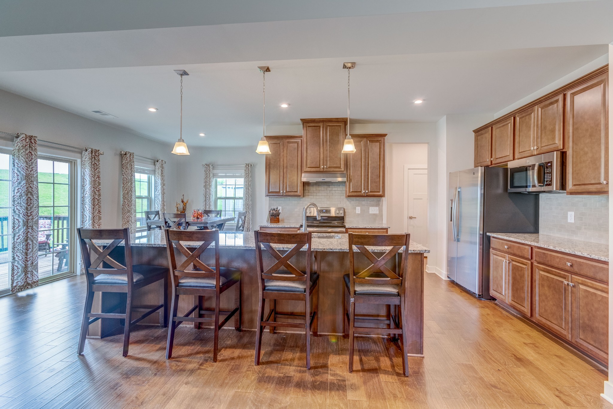 315 Collier Road Mount Juliet, TN 37122 - Photo 8 of 34 a kitchen with stainless steel appliances kitchen island granite countertop a table chairs and a refrigerator