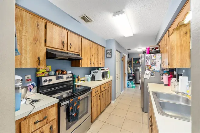 a kitchen with stainless steel appliances granite countertop a sink stove and cabinets