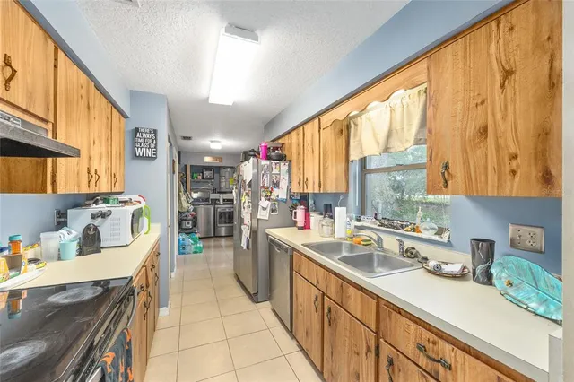 a kitchen filled a sink a counter top space and stainless steel appliances
