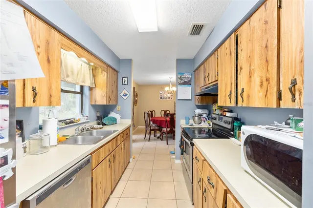 a kitchen filled a sink a counter top space and stainless steel appliances