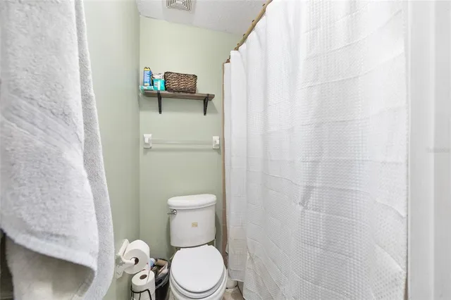 a white toilet sitting next to a shower curtain