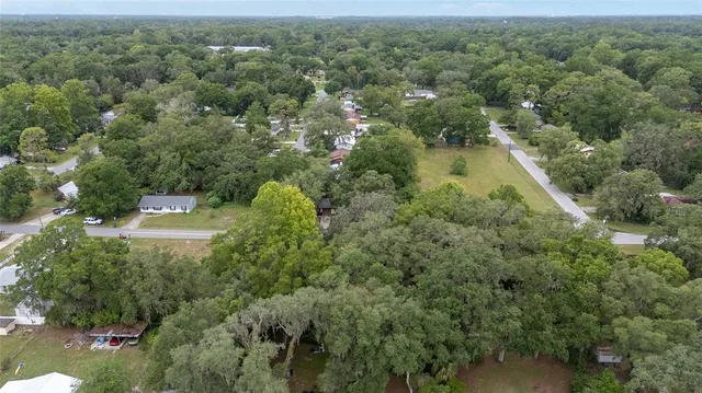 an aerial view of a house with a yard and lake view