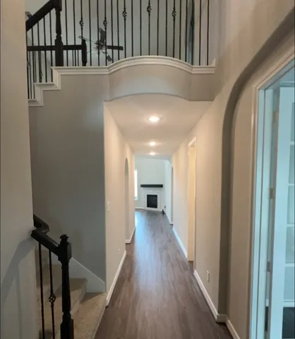 a view of a hallway with wooden floor and staircase