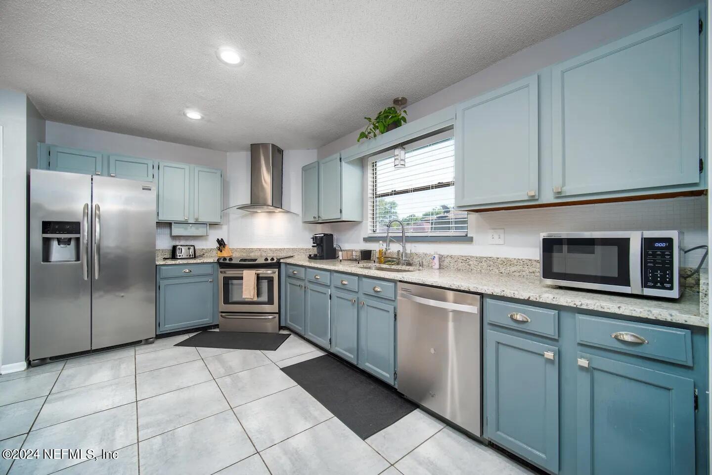 10062 Hawks Hollow Road Jacksonville, FL 32257 - Photo 12 of 39 a kitchen with stainless steel appliances granite countertop a stove a sink and a microwave