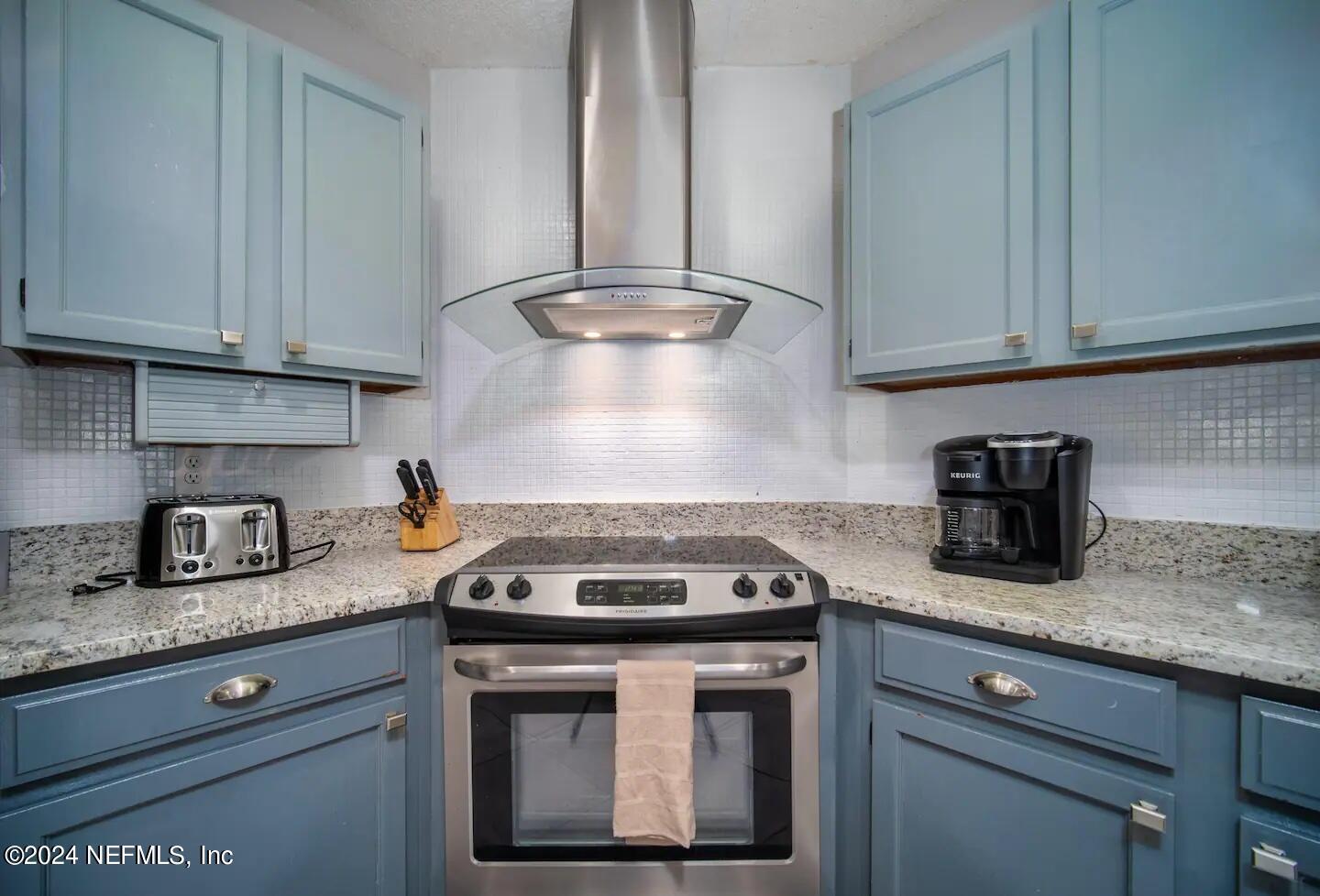 10062 Hawks Hollow Road Jacksonville, FL 32257 - Photo 14 of 39 a kitchen with granite countertop a stove sink and cabinets