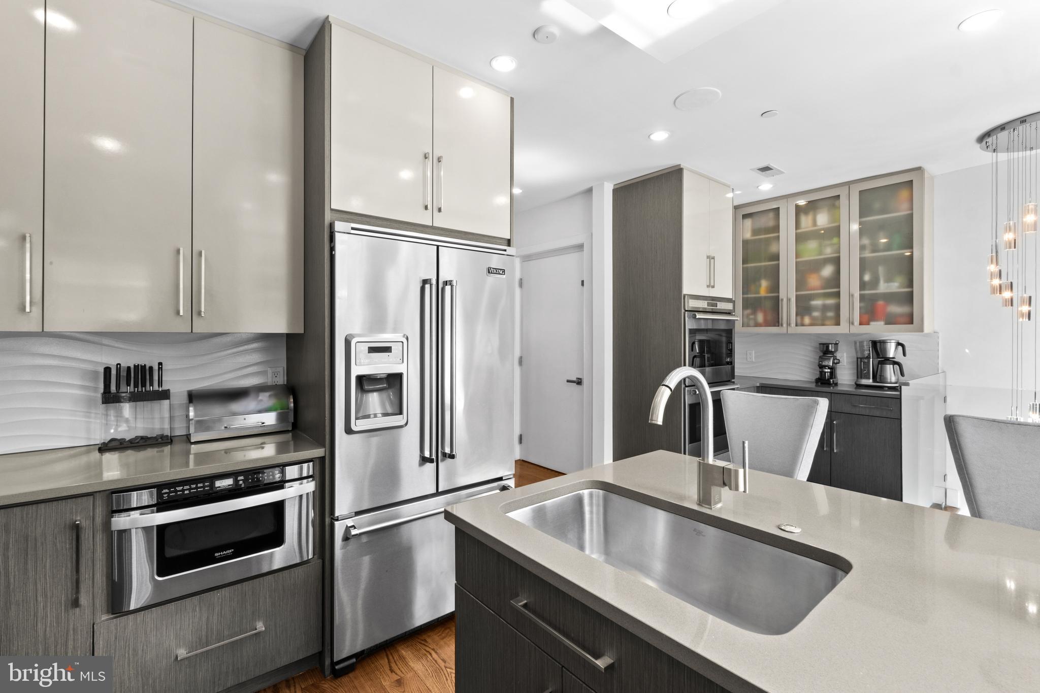 1815 Lombard Street Philadelphia, PA 19146 - Photo 26 of 79 a kitchen with stainless steel appliances granite countertop a sink a stove and a refrigerator with wooden floor