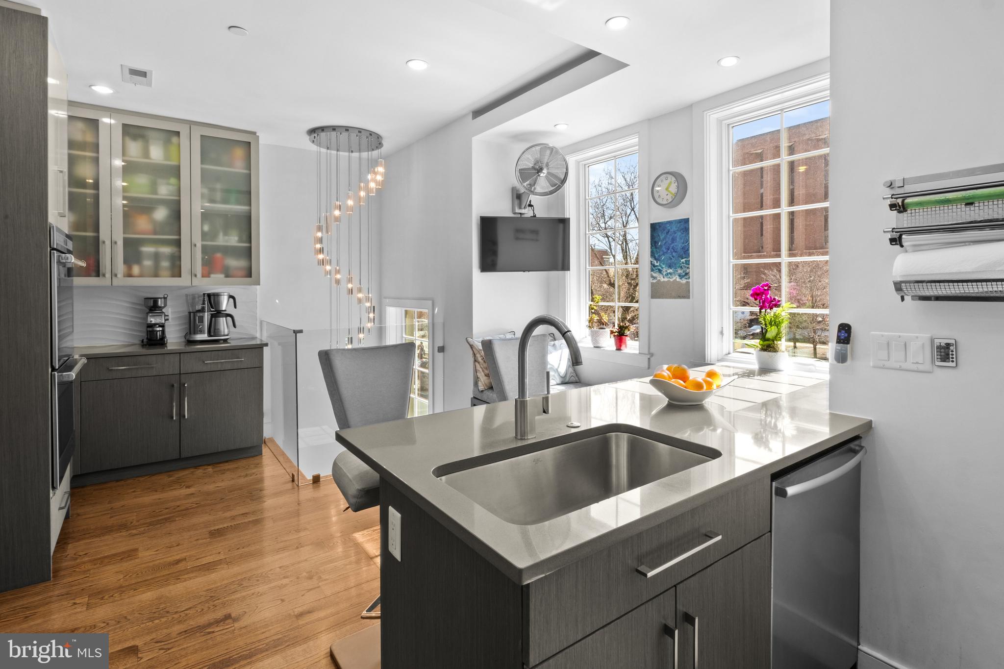1815 Lombard Street Philadelphia, PA 19146 - Photo 28 of 79 a kitchen with a sink dishwasher a stove and a dining table with wooden floor