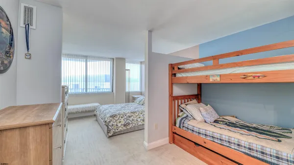a bedroom with a bed and a dresser next to a window