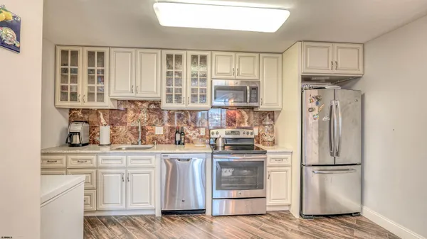 a kitchen with stainless steel appliances granite countertop a refrigerator and a stove top oven