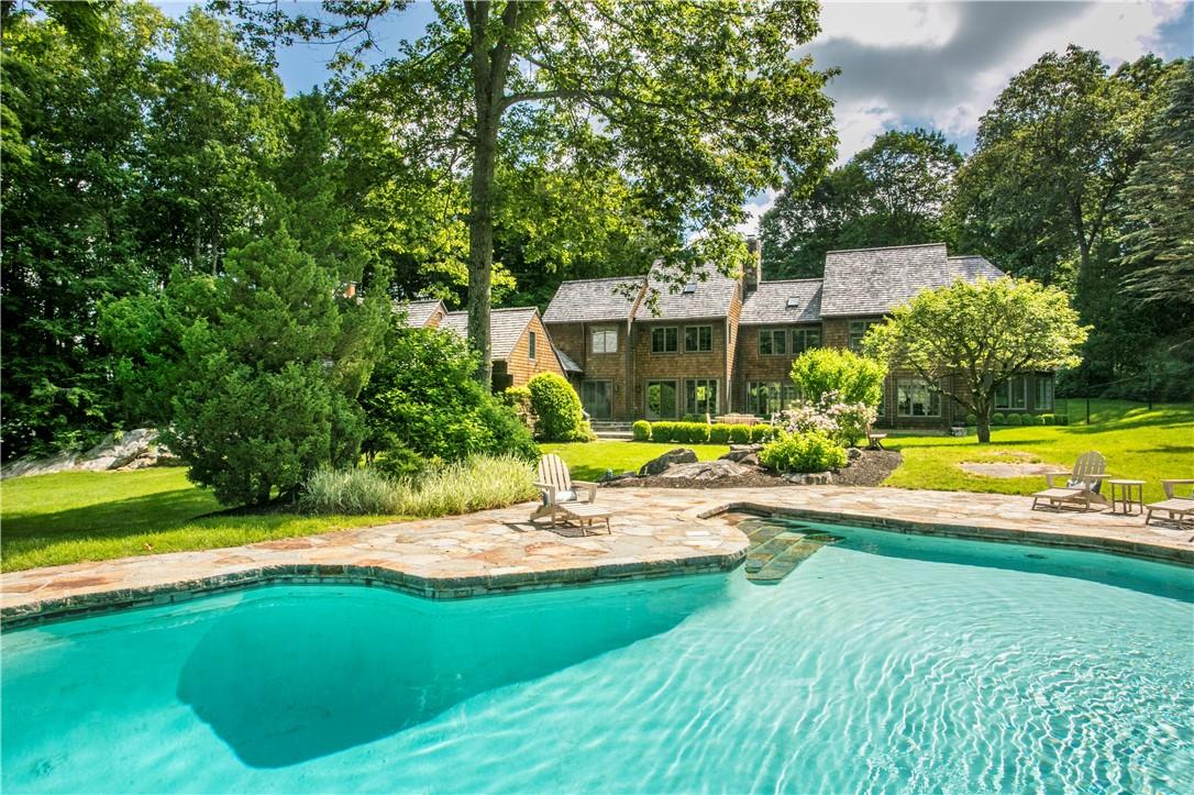 a view of a swimming pool with a patio and a yard