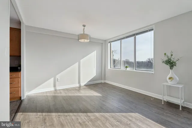 wooden floor in an empty room with a kitchen