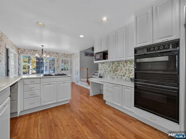 a kitchen with granite countertop white cabinets and white appliances
