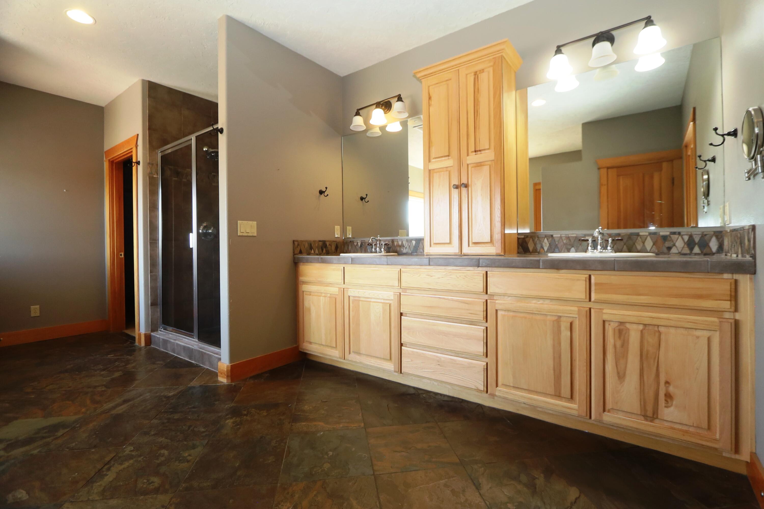 21491 Bear Creek Road Bend, OR 97701 - Photo 19 of 45 a spacious bathroom with a granite countertop sink mirror and double
