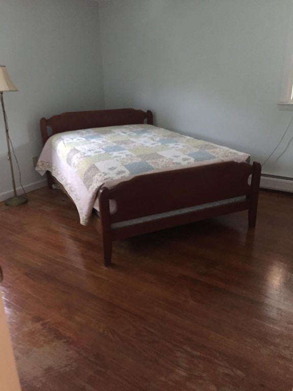 185 Chudy Street Three Rivers, MA 01080 - Photo 15 of 16 a bed sitting in a bedroom next to a wooden table and chair