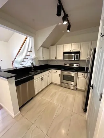 a kitchen with stainless steel appliances granite countertop a sink a stove a microwave and cabinets