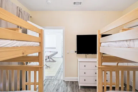 a kitchen with stainless steel appliances a dining table chairs wooden floor and a refrigerator