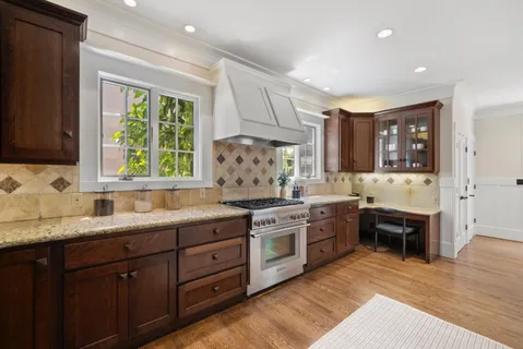 a kitchen with stainless steel appliances kitchen island granite countertop wooden floors and view living room