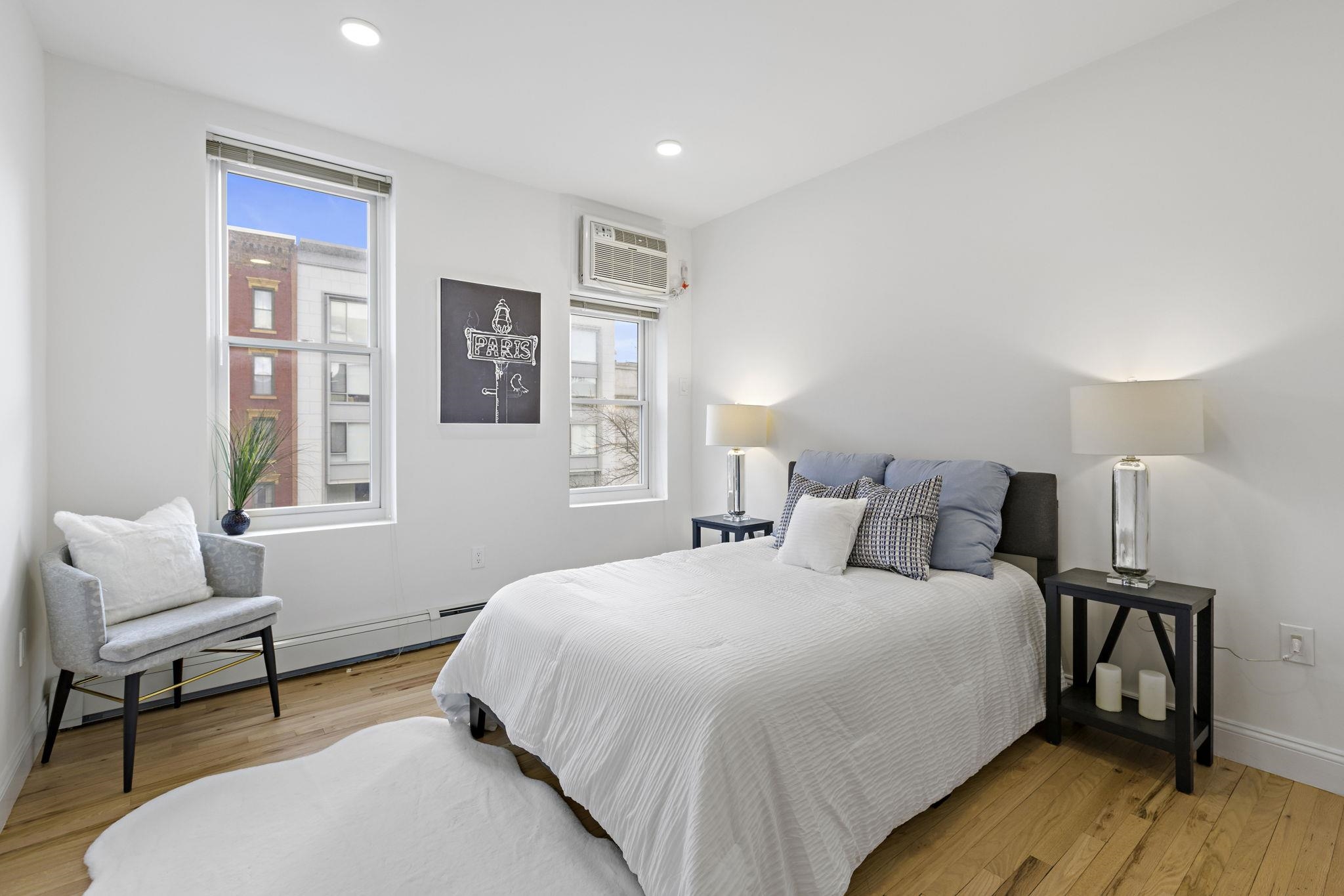 110 Washington Street, Unit 5 Hoboken, NJ 07030 - Photo 13 of 21 a bedroom with a bed a chair and wooden floor