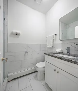 a bathroom with a granite countertop sink a toilet and a mirror
