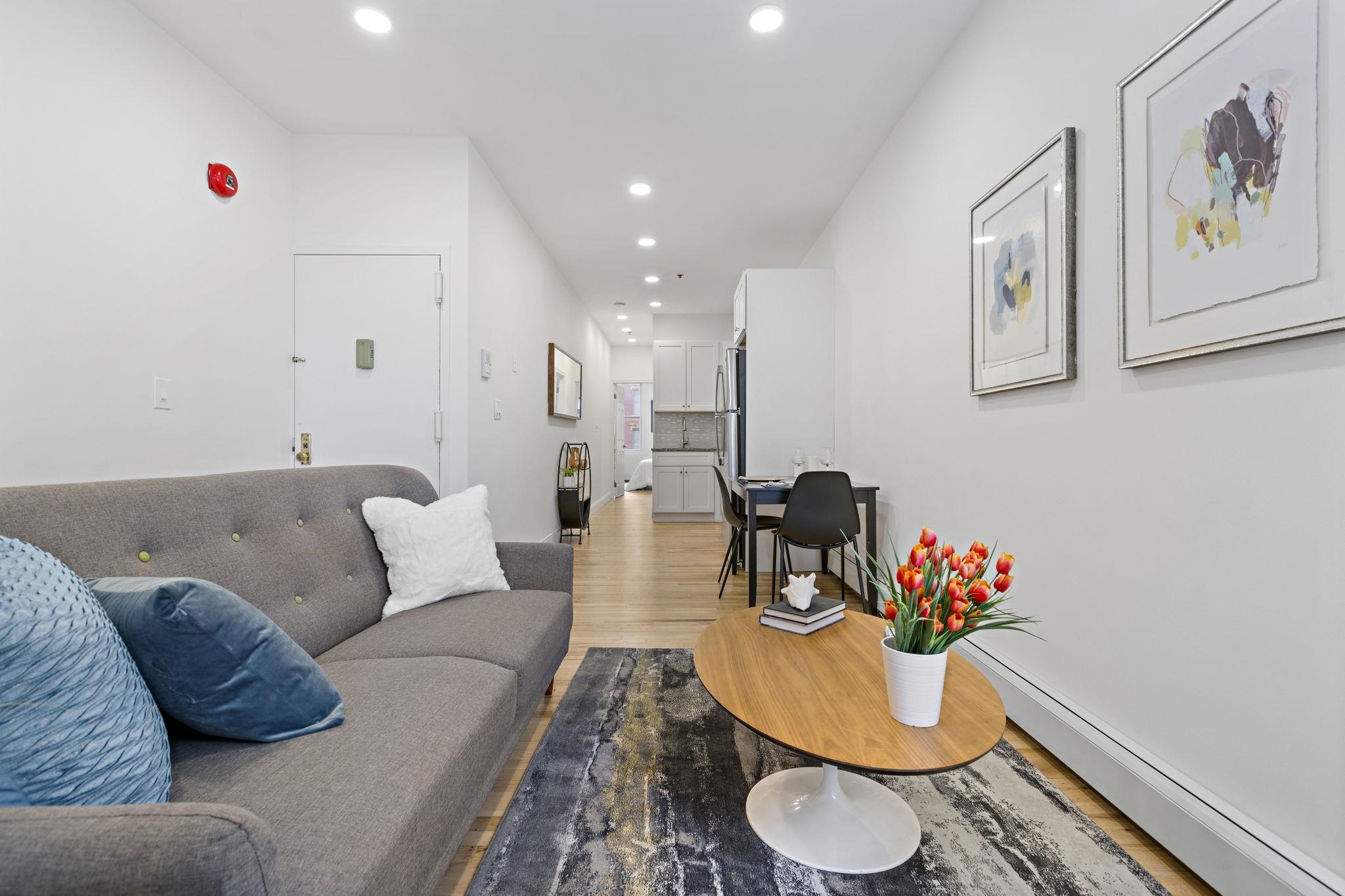 110 Washington Street, Unit 5 Hoboken, NJ 07030 - Photo 2 of 21 a living room with furniture and a dining table