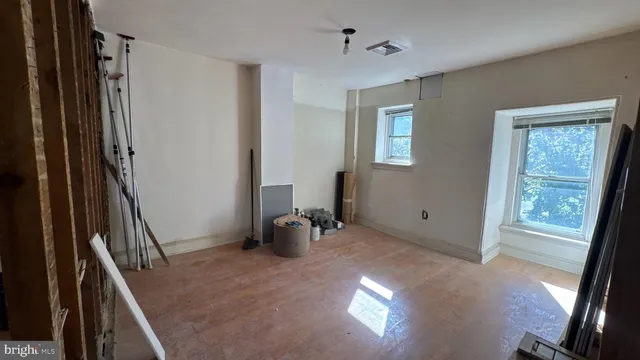 a view of empty room with wooden floor and fireplace