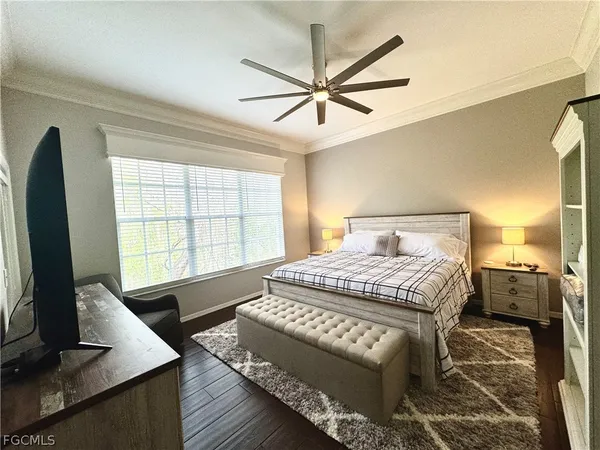 a bedroom with a large bed and a flat tv screen on dresser