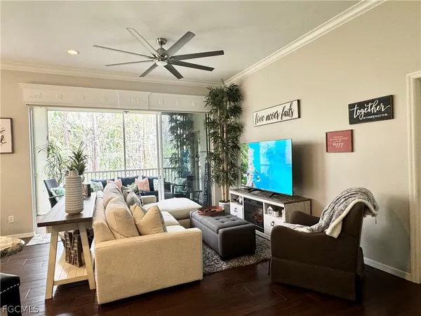 a living room with furniture a ceiling fan and a window