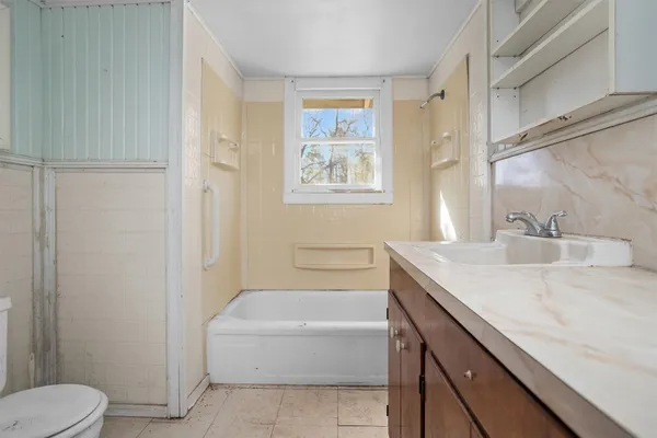 a bathroom with a granite countertop sink a toilet and bathtub