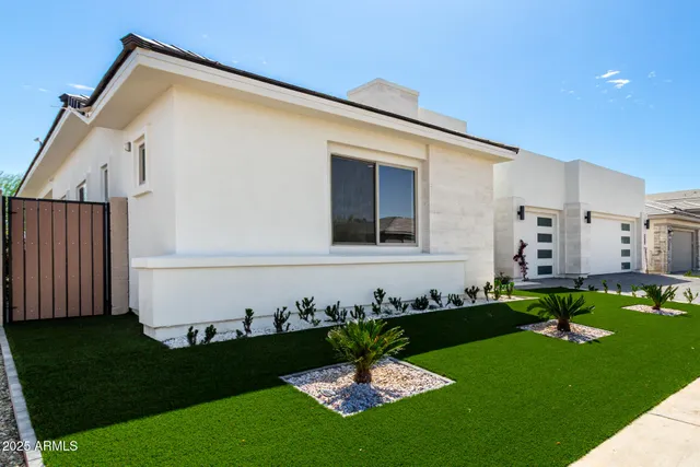 a front view of a house with a garden and yard