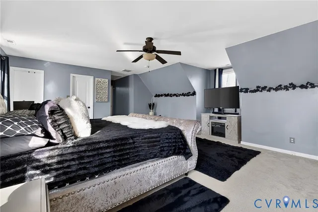 a bedroom with a large bed and a chandelier