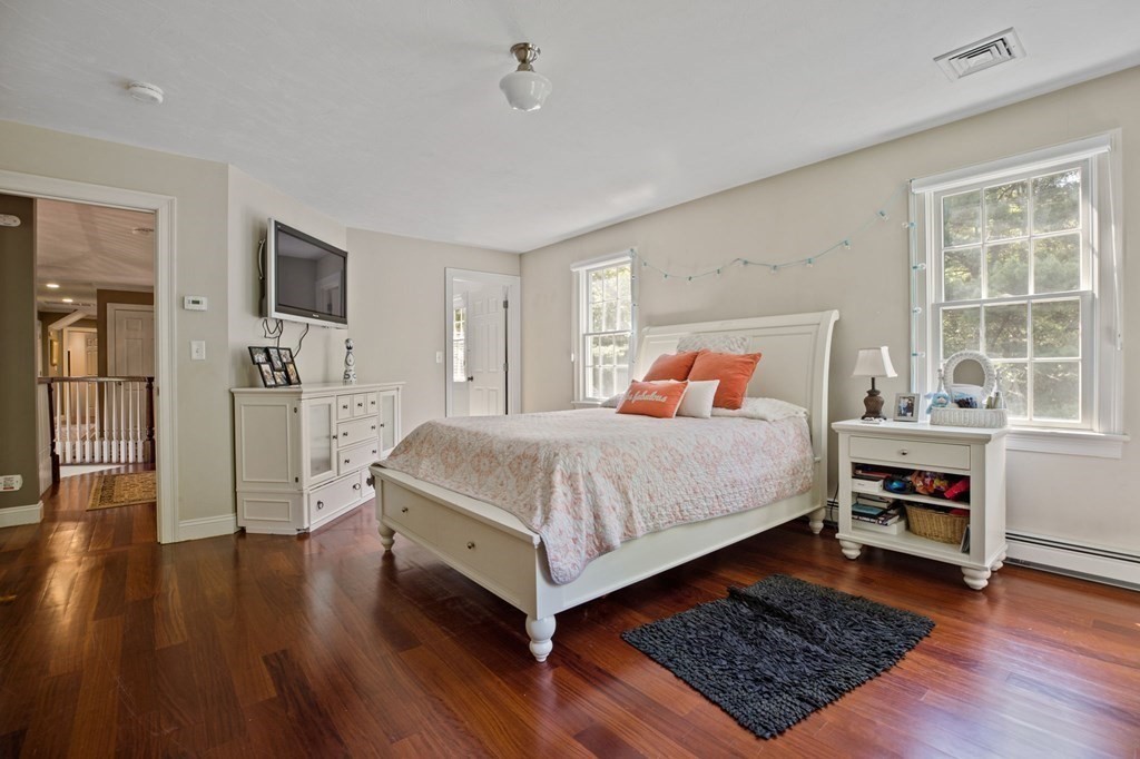 352 Clapp Road Scituate, MA 02066 - Photo 21 of 41 a bedroom with a bed and wooden floor