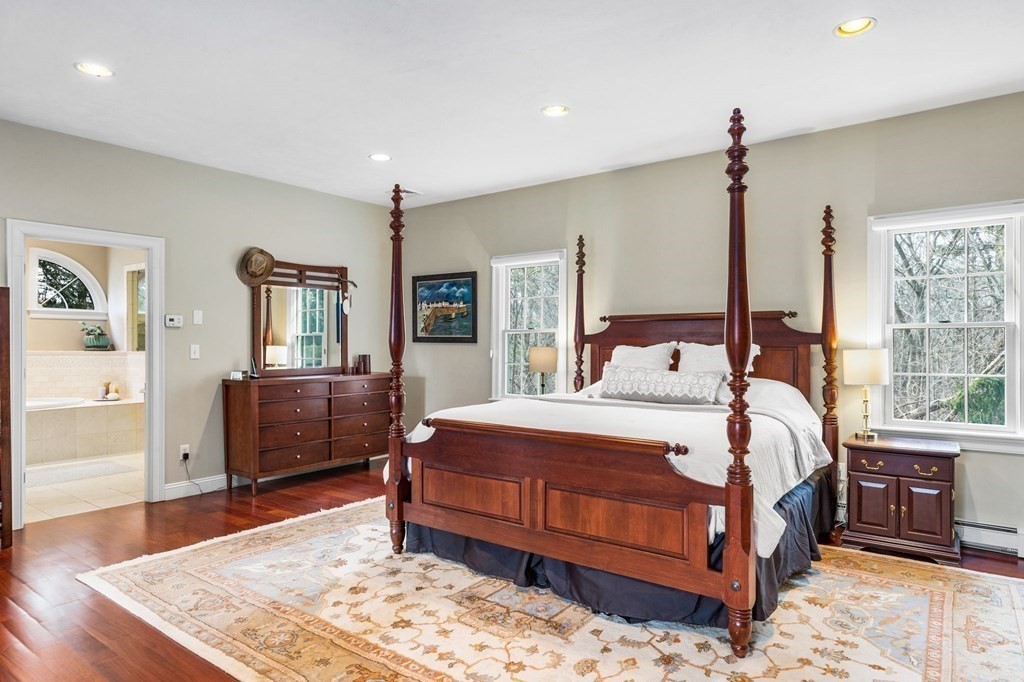 352 Clapp Road Scituate, MA 02066 - Photo 23 of 41 a bedroom with a large bed a chandelier and dresser