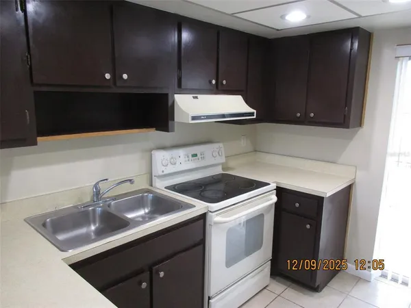 a kitchen with a sink a refrigerator and cabinets