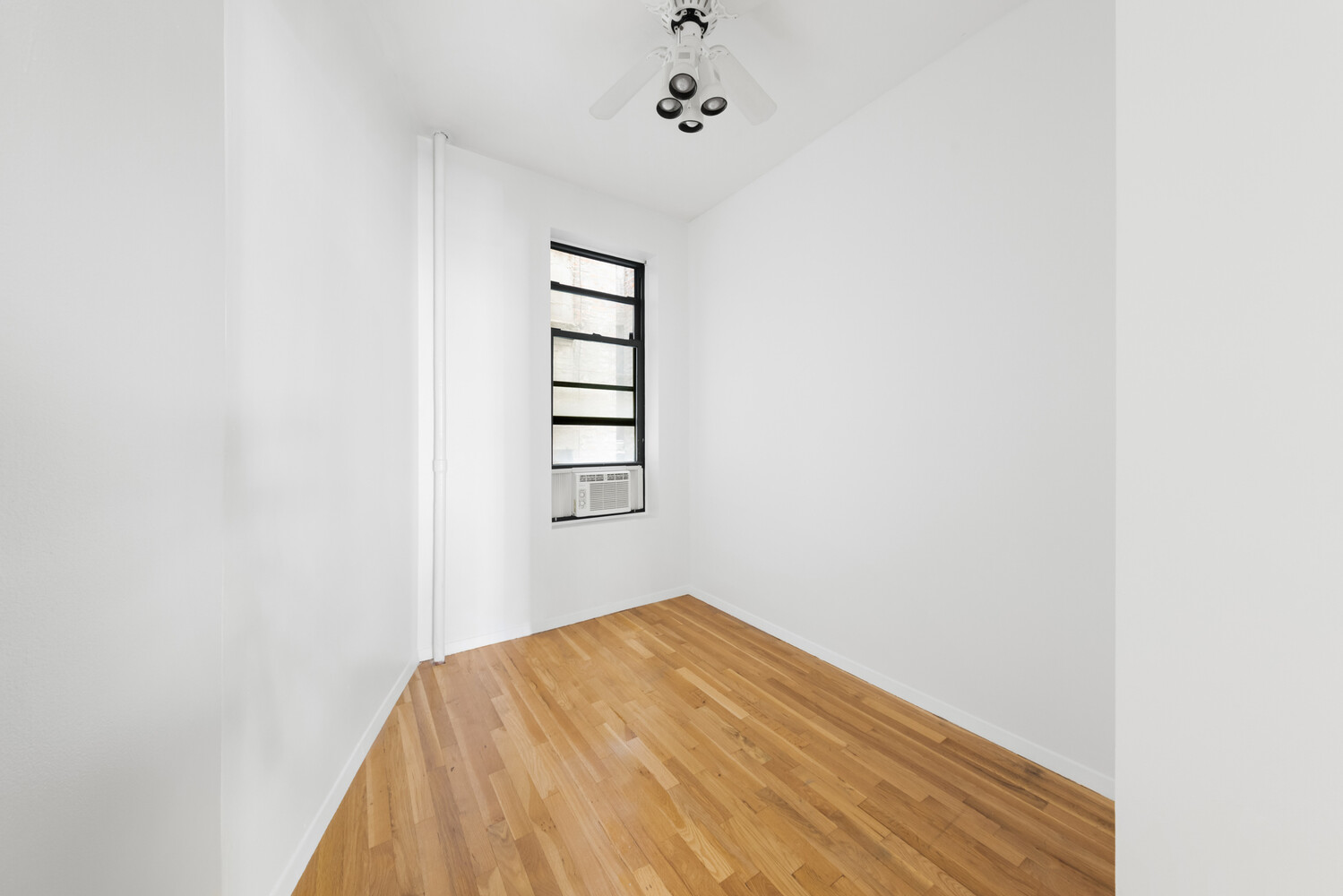332 East 77th Street, Unit 11 Manhattan, NY 10075 - Photo 5 of 11 a view of a bedroom with a bed and a window