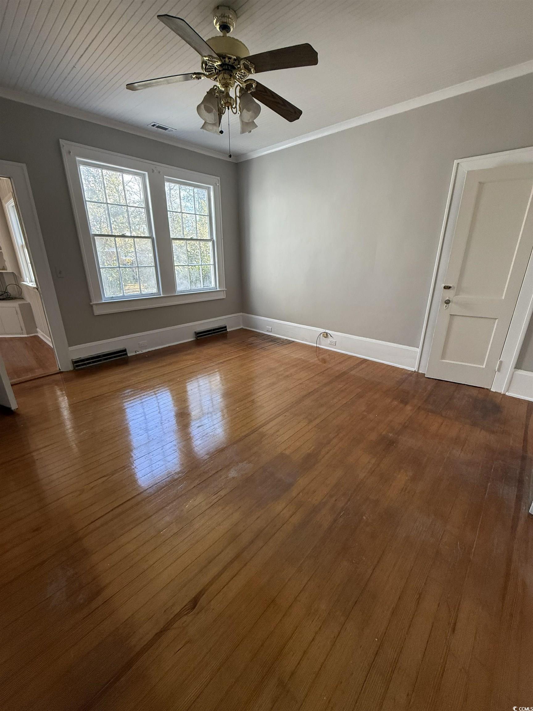 305 East Bamberg Street Latta, SC 29565 - Photo 5 of 13 Empty room featuring ornamental molding, a ceiling fan, dark wood finished floors, and wood ceiling