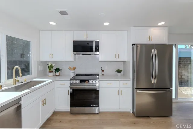 a kitchen with cabinets stainless steel appliances and a sink