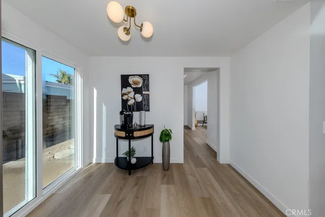 a view of a room with wooden floor table and windows