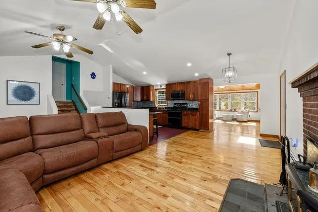 a living room with furniture kitchen view and a chandelier