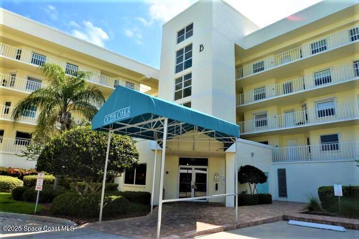 8700 Ridgewood Avenue, Unit B310 Cape Canaveral, FL 32920 - Photo 1 of 23 a front view of a building with glass windows and a garage