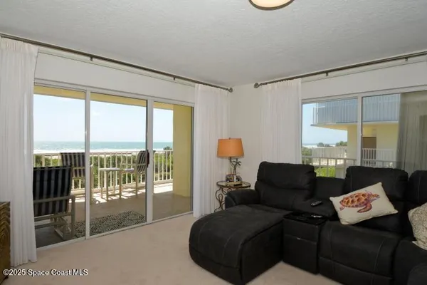 a living room with furniture and a floor to ceiling window