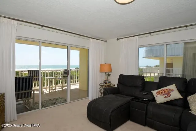 a living room with furniture and a floor to ceiling window