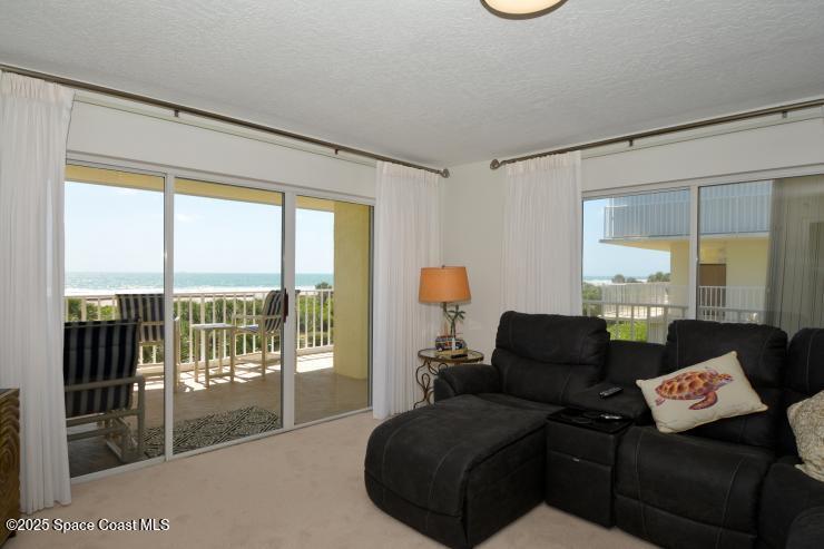 8700 Ridgewood Avenue, Unit B310 Cape Canaveral, FL 32920 - Photo 11 of 23 a living room with furniture and a floor to ceiling window