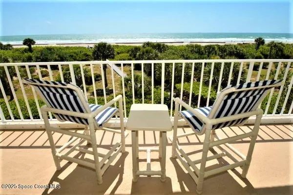 a view of a balcony with wooden floor and outdoor seating
