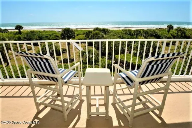 a view of a balcony with wooden floor and outdoor seating