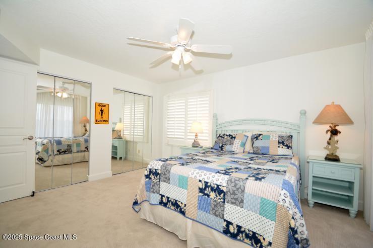8700 Ridgewood Avenue, Unit B310 Cape Canaveral, FL 32920 - Photo 15 of 23 a bedroom with a bed a couch and dresser