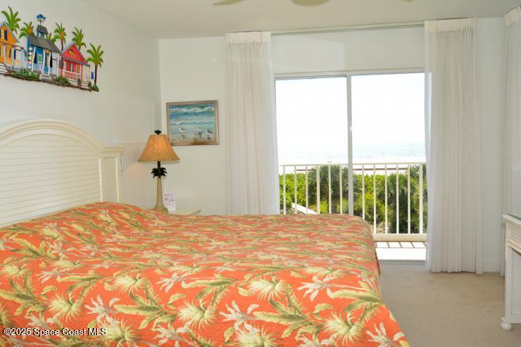 8700 Ridgewood Avenue, Unit B310 Cape Canaveral, FL 32920 - Photo 19 of 23 a bedroom with a bed and a window